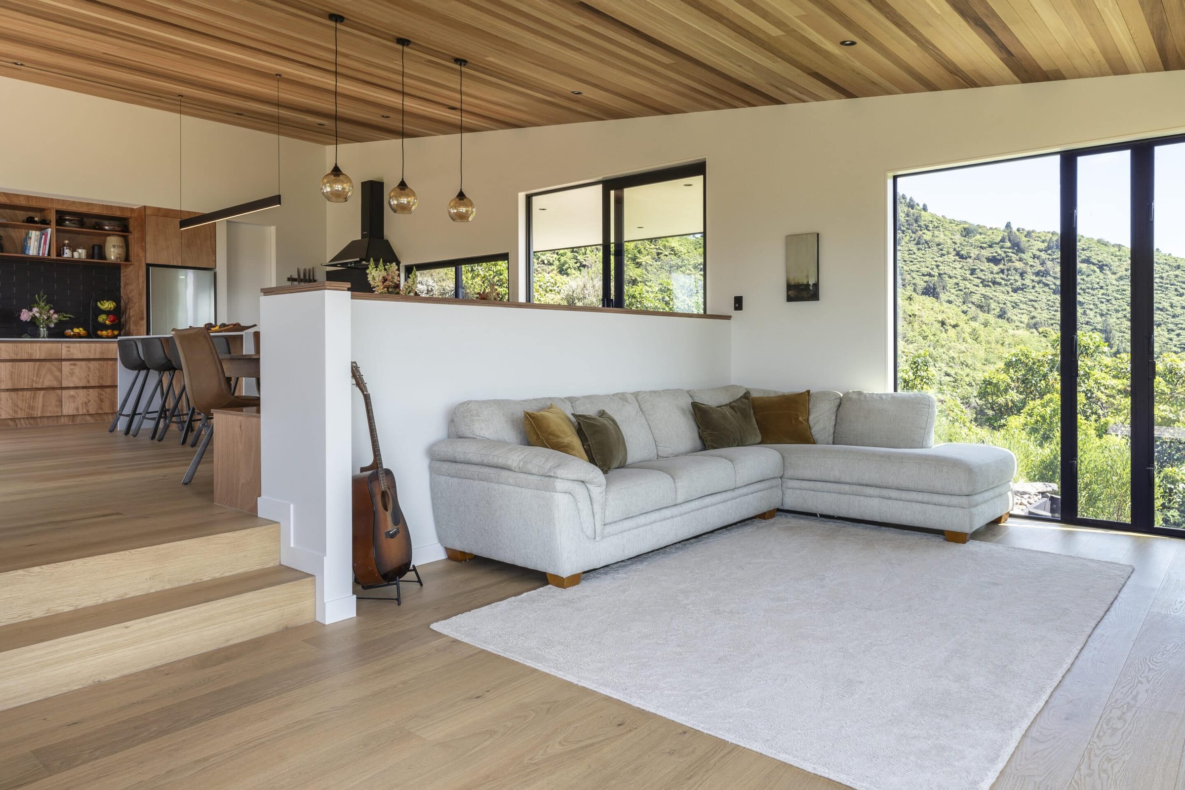 An open-plan New Zealand living room with a light oak timber floor.