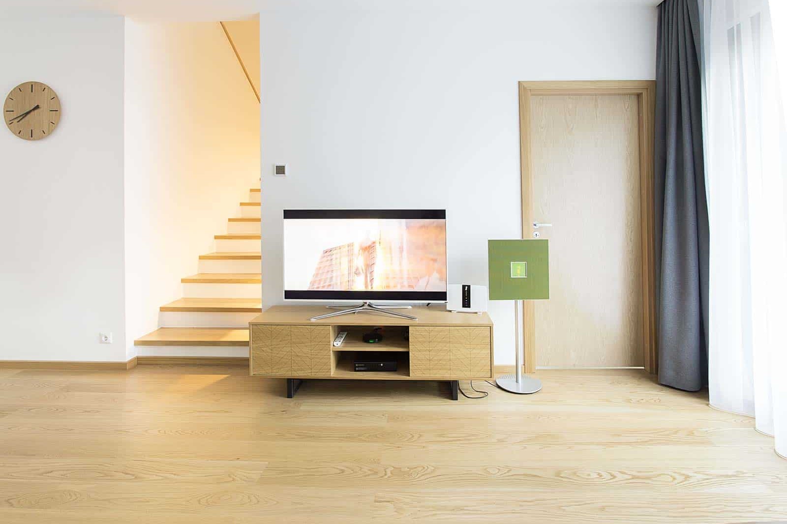 Lacquered oak timber floor in a light living room, the sealed surface catching a soft sheen.